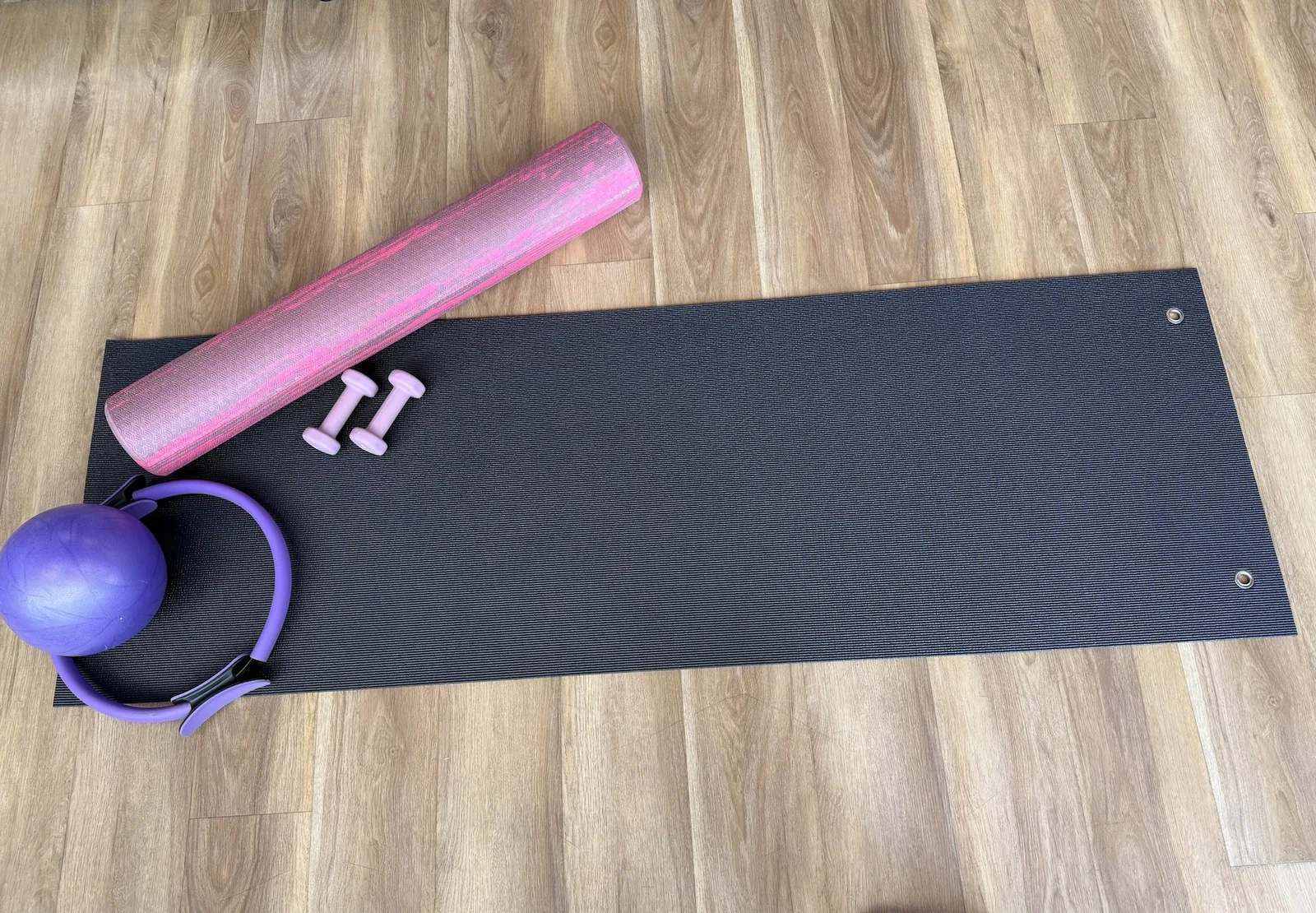 Pilates mat with foam roller, light dumbbells, Pilates ring, and ball