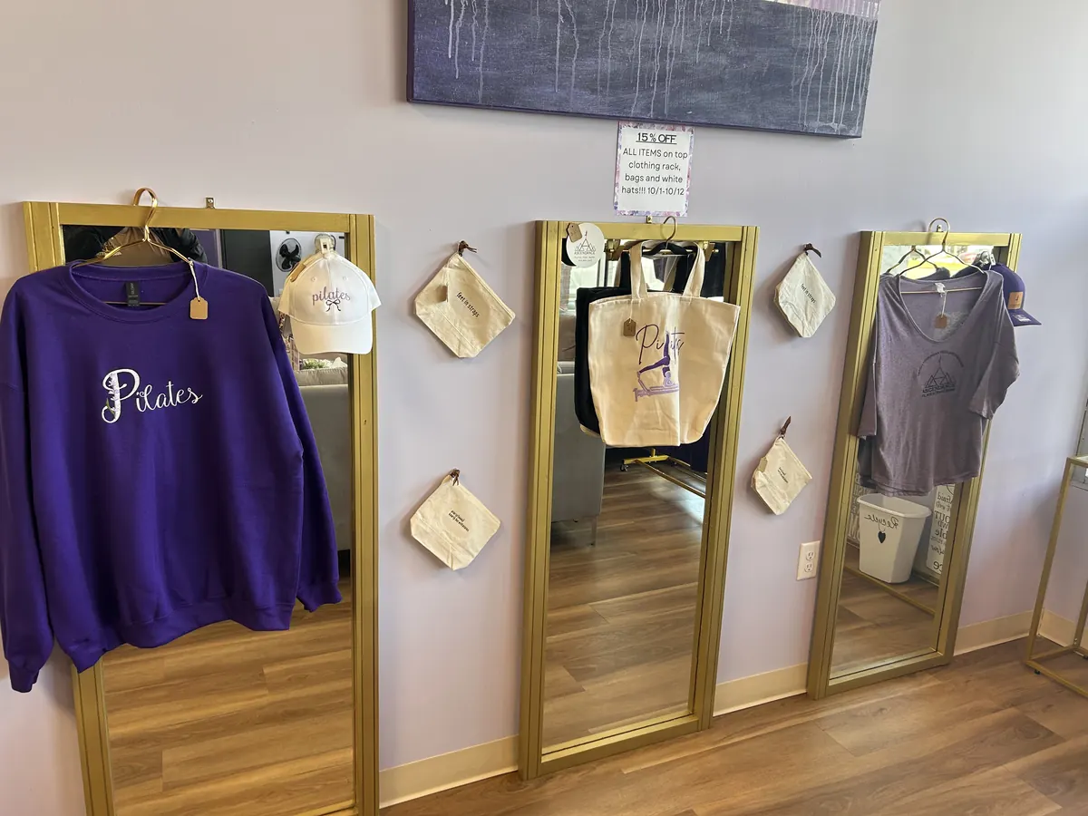 Ascendance apparel and accessories displayed between gold-framed mirrors in the studio